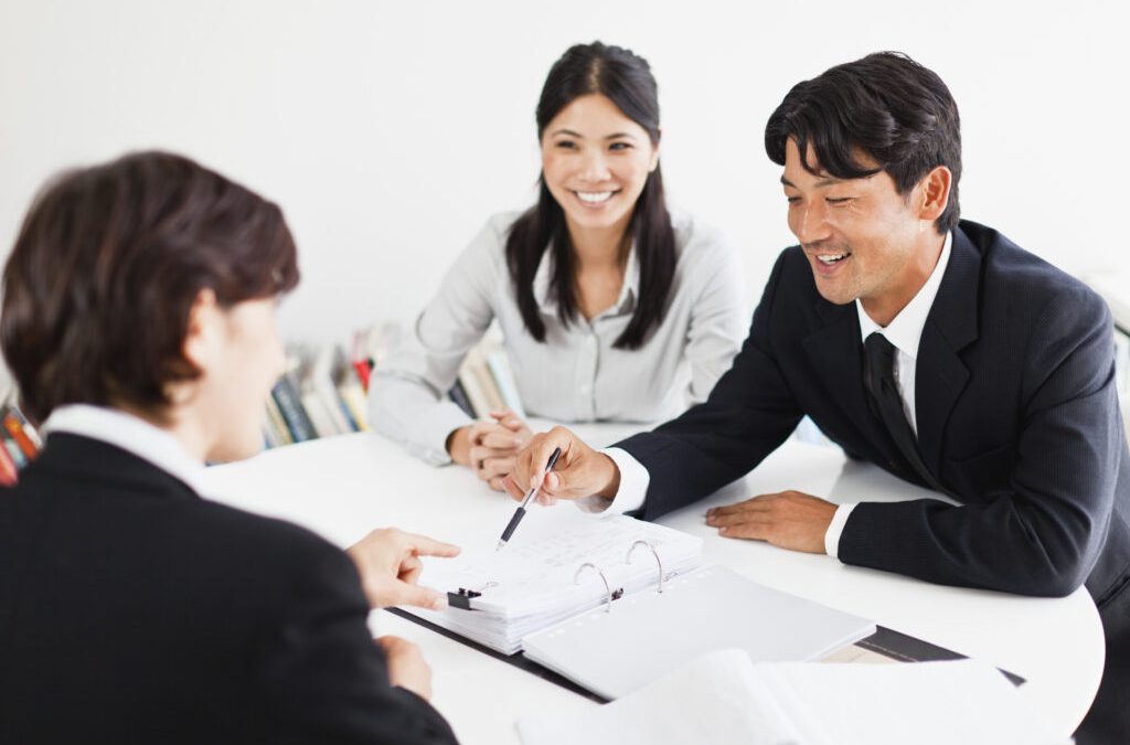 Business professionals reviewing documents in an office meeting, representing key considerations when choosing health insurance for large businesses.