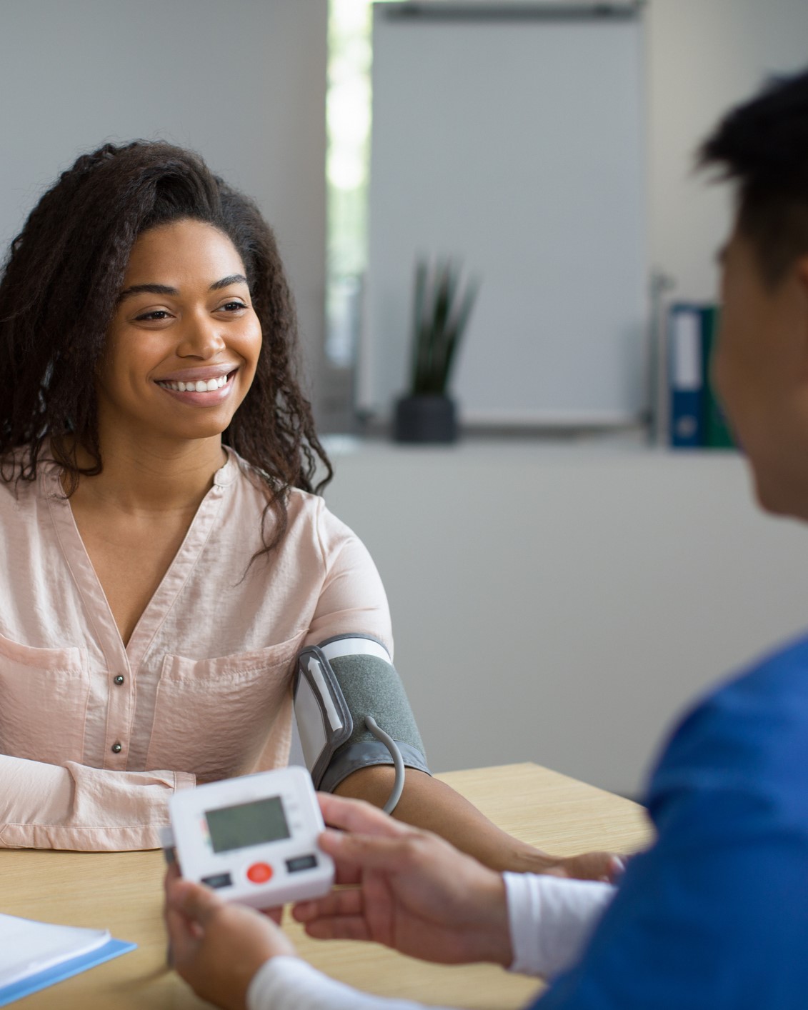 A small business employee receiving an eye exam from an optometrist, representing the importance of vision insurance for workplace wellness.